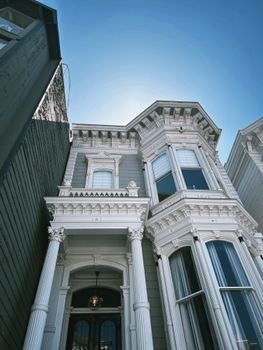 Charming white Victorian-style home with intricate details bathed in daylight.