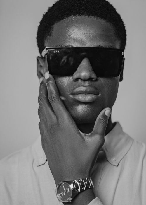 Free Elegant black and white portrait of a man wearing sunglasses and a wristwatch. Stock Photo