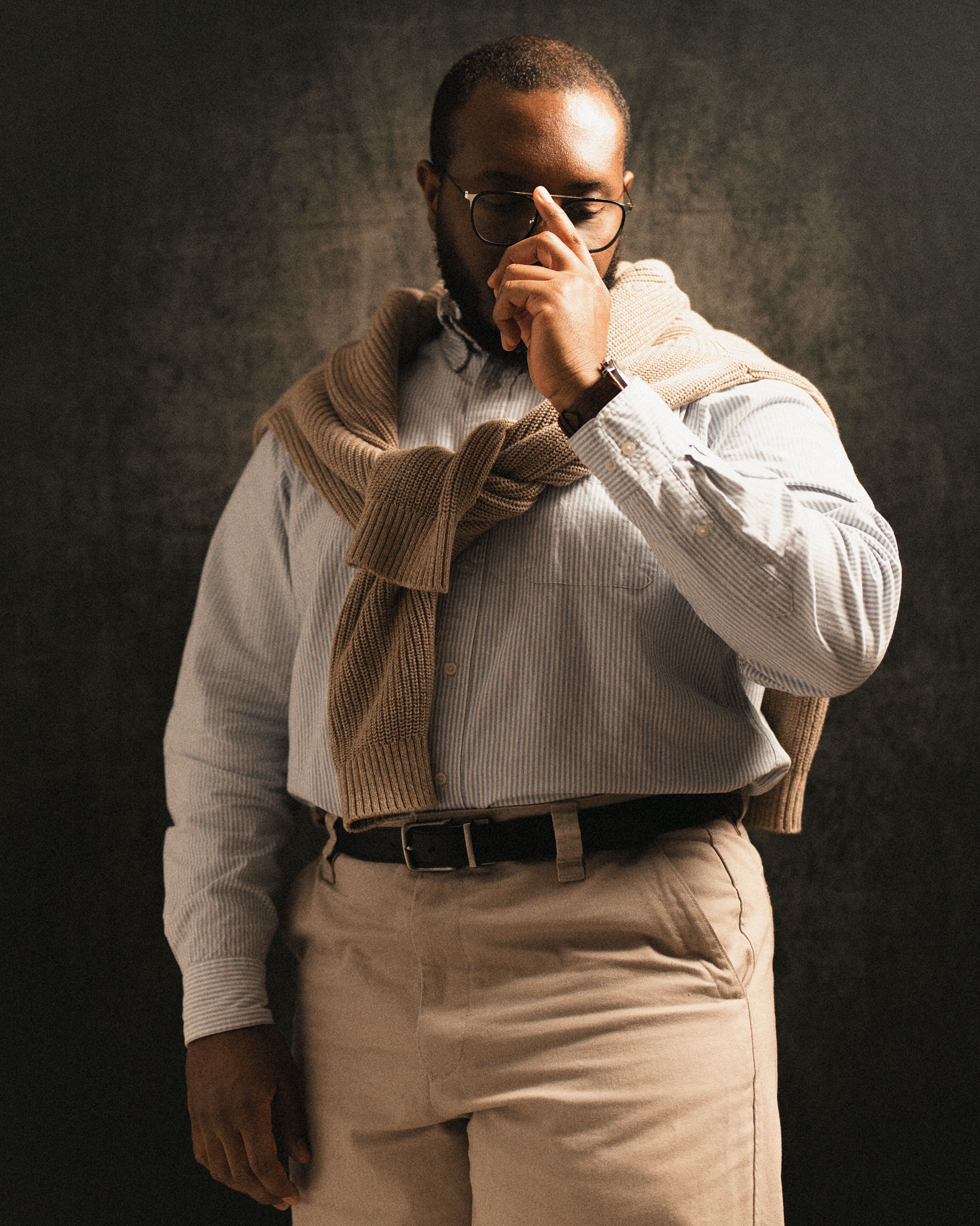 Portrait of a stylish man in a classic outfit with a contemplative pose.