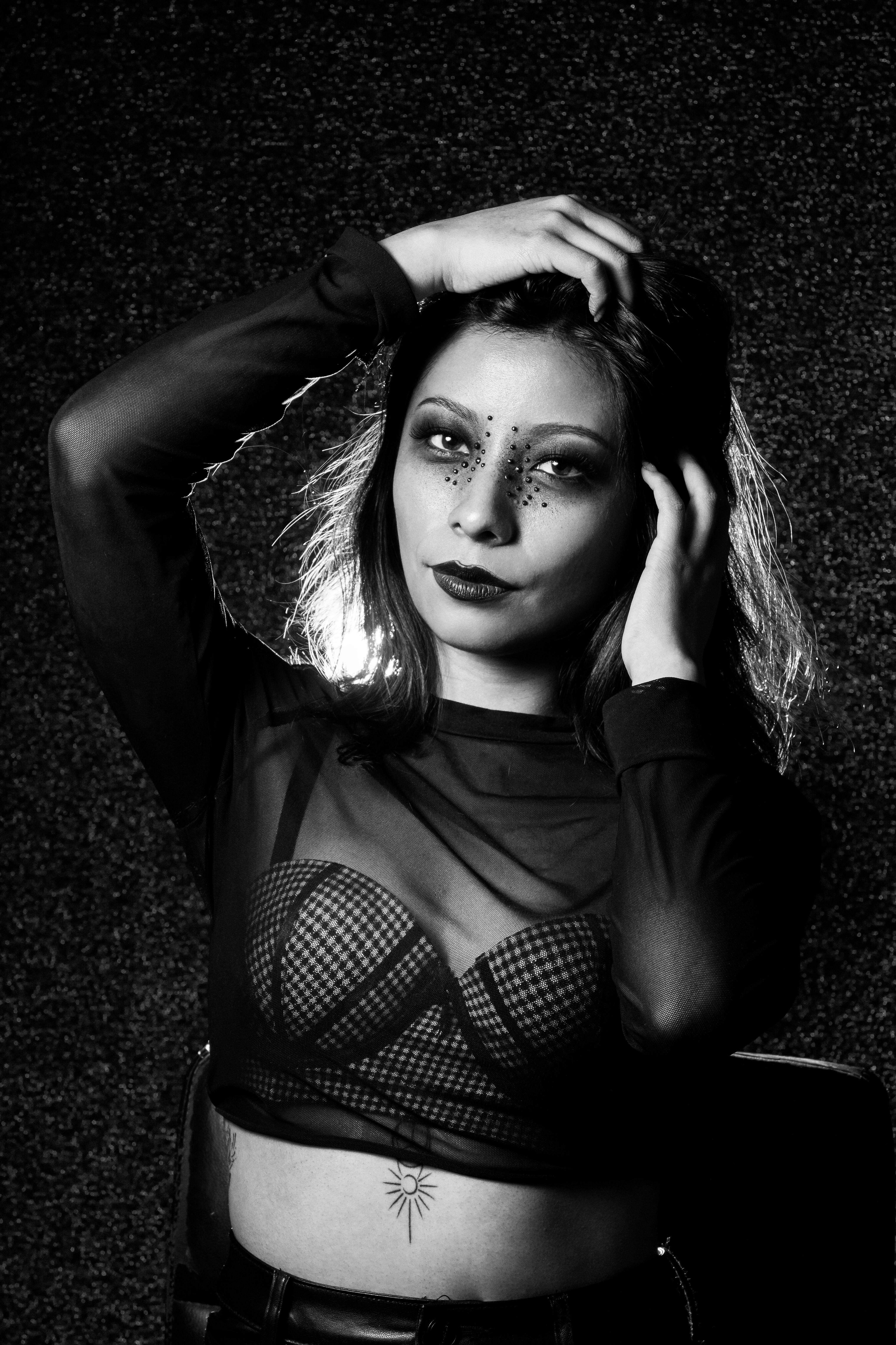 Gratis Slående svart-hvitt-portrett av en kvinne med dristig kunstnerisk sminke og stilig motepositur. Arkivbilde