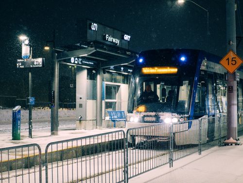 Free A snowy night at Fairway Station in Kitchener, Ontario with a light rail transit arriving. Stock Photo