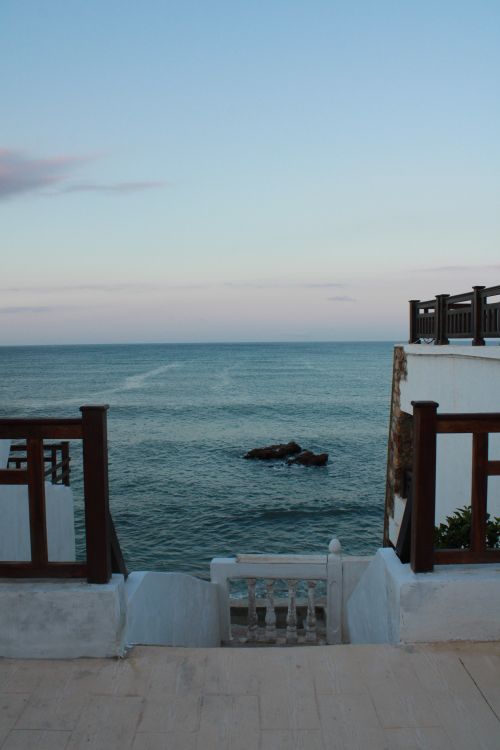 Free A peaceful ocean view framed by white architecture on the Moroccan coastline. Stock Photo