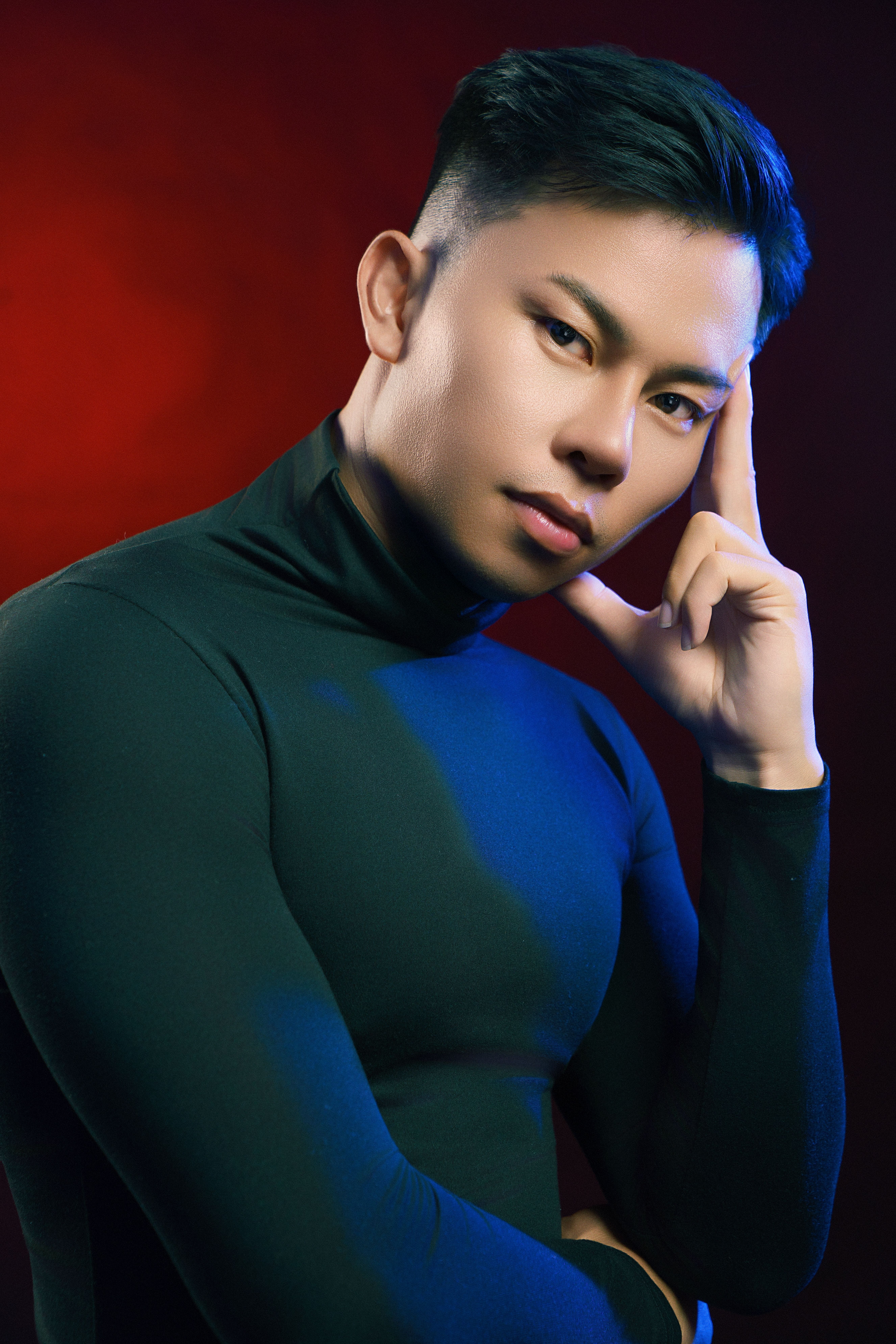 Studio portrait of a young Asian male model with creative lighting and a serious expression in Ho Chi Minh City.
