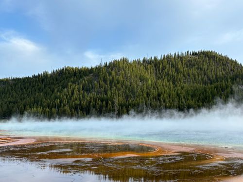 Free A breathtaking view of the Grand Prismatic Spring with rising steam in Yellowstone National Park. Stock Photo