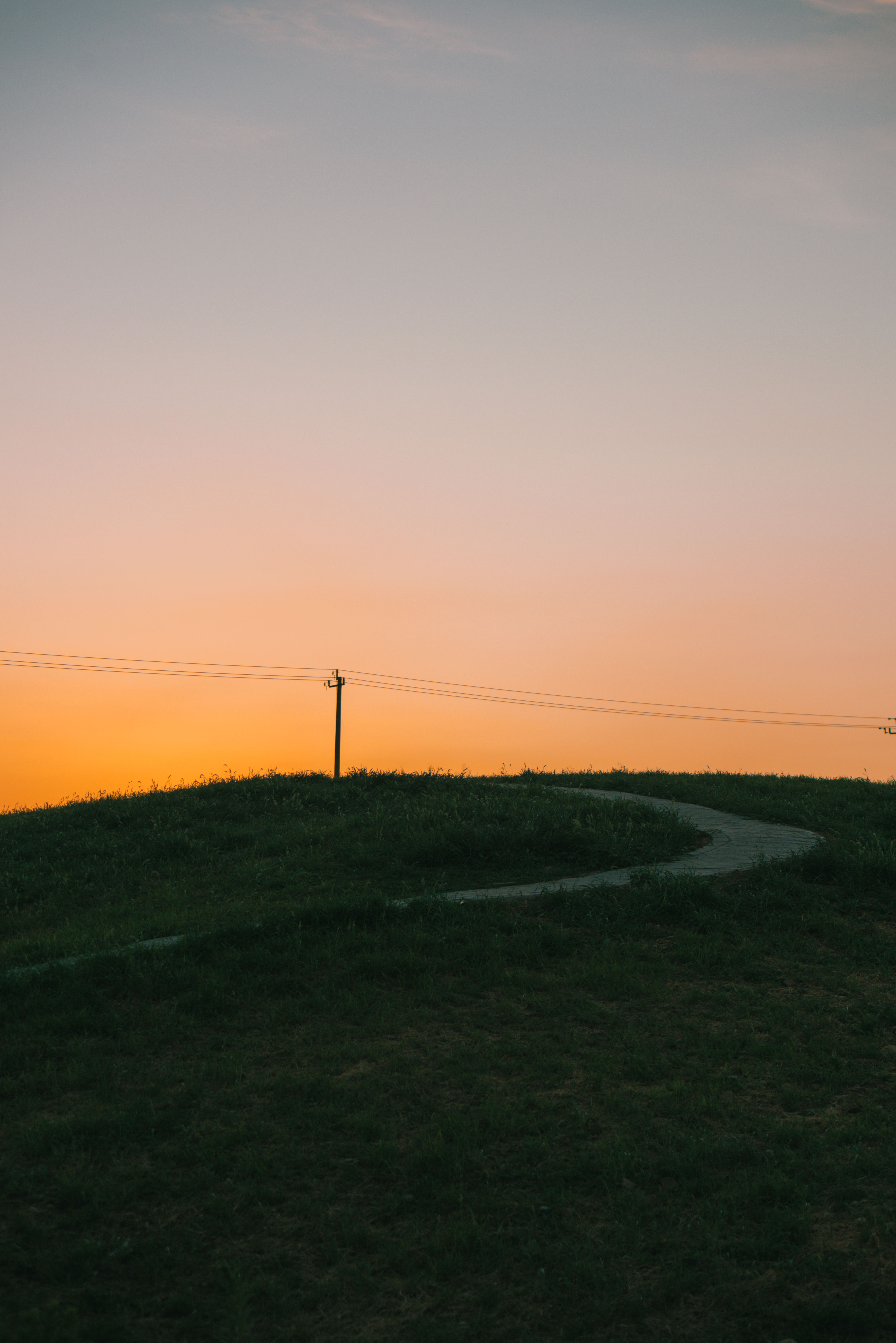 Serene Sunset Over Rolling Hills With Pathway · Free Stock Photo