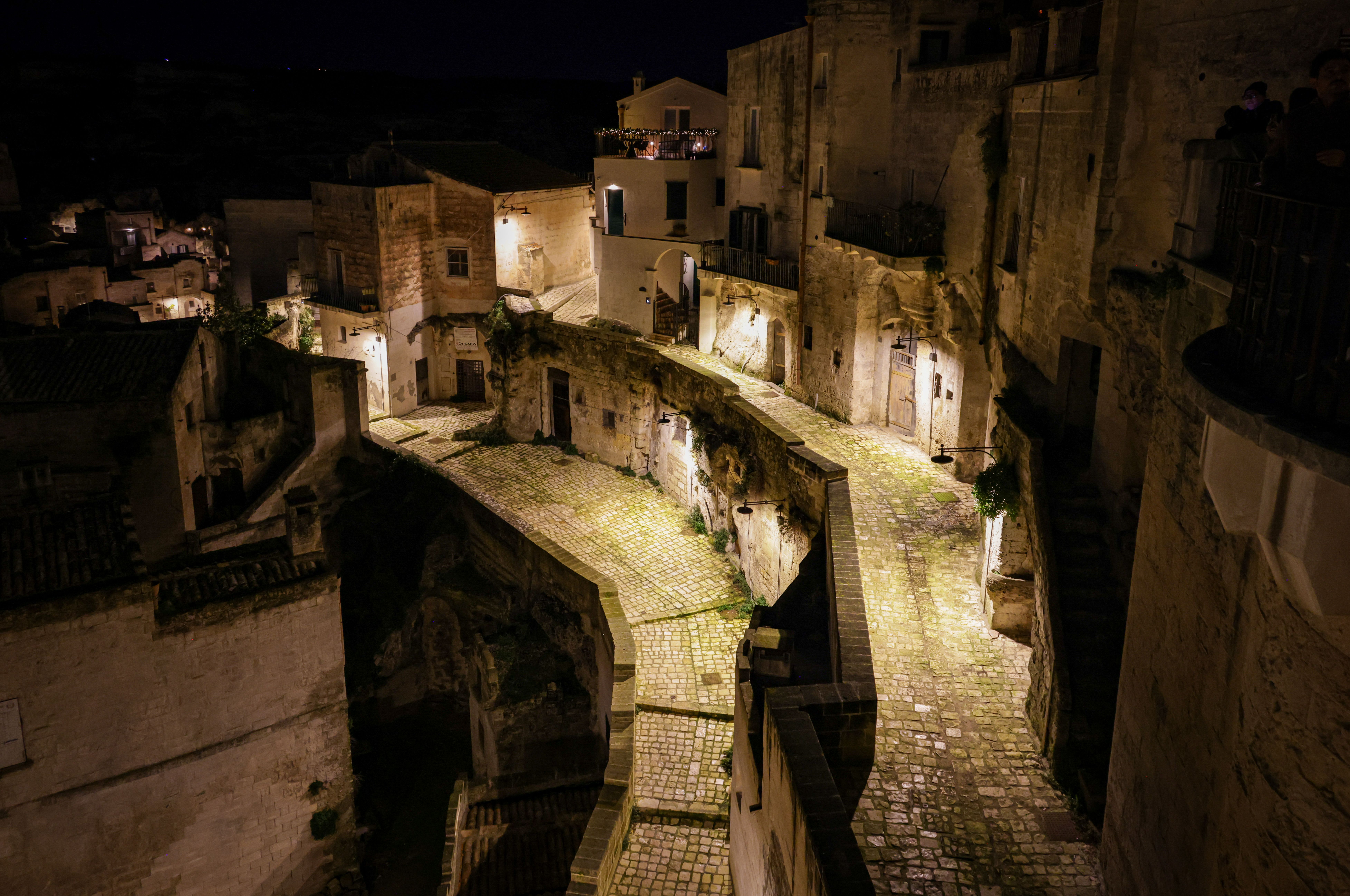 Beautifully lit streets of Matera at night showcasing Italian architecture and village charm.