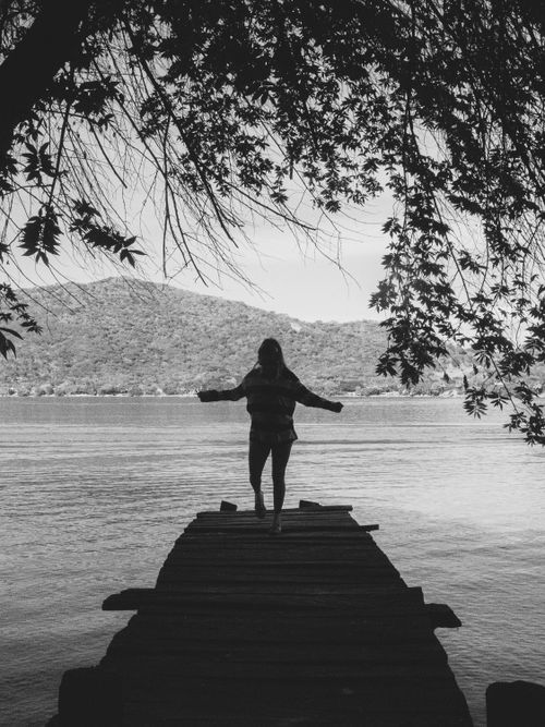 Free Black and white photo of a woman standing on a pier at La Laguna, Nayarit, Mexico. Stock Photo