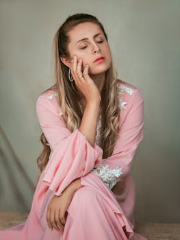 身着粉衣的优雅女人闭着双眼，散发着平静与美丽