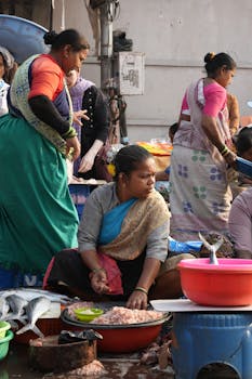 Local vendors selling fresh seafood at a bustling outdoor fish market.