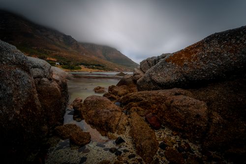 Free Explore the serene and dramatic rocky seascape of Cape Town's coastline under a moody sky. Stock Photo