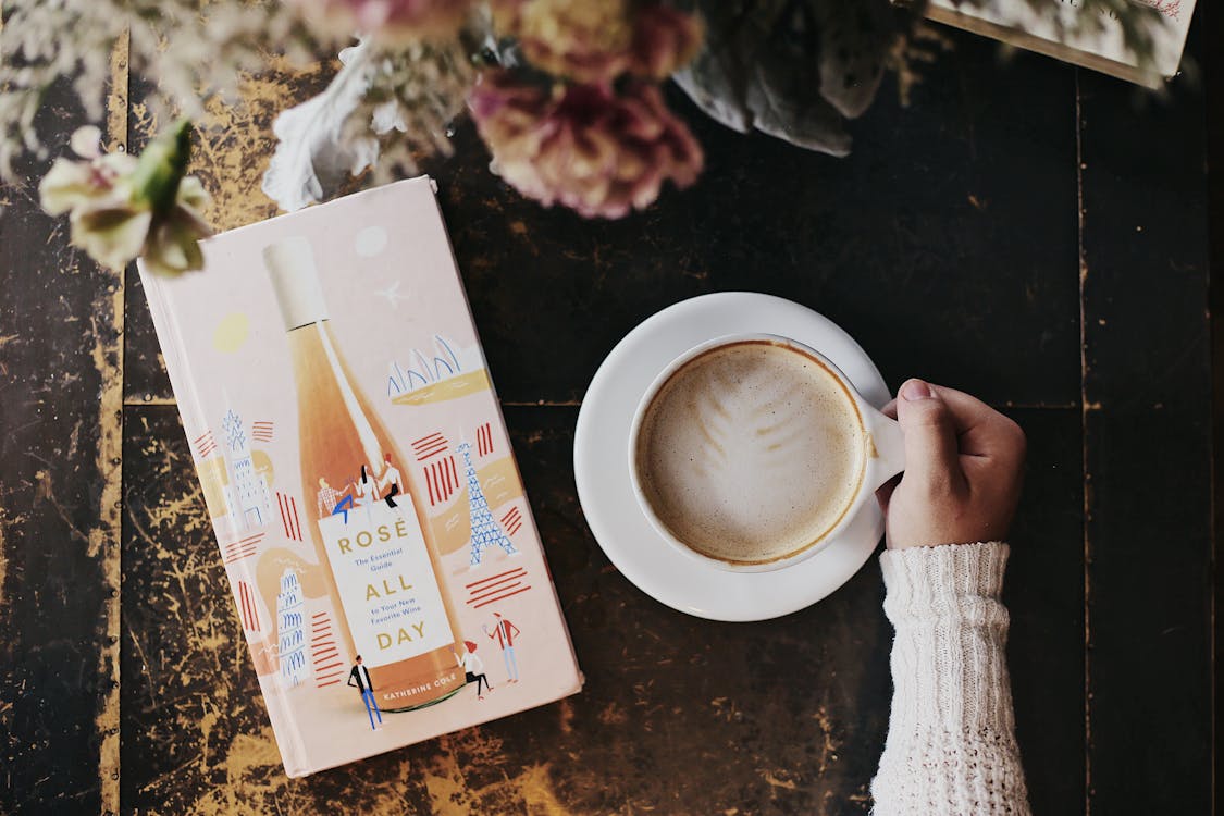 Free A hand holding a cup of beverage Stock Photo