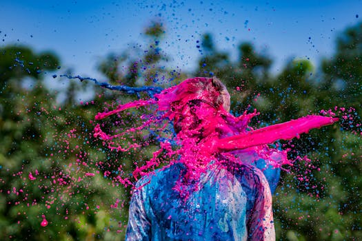 Man covered in vibrant colors during Holi festival celebration outdoors.