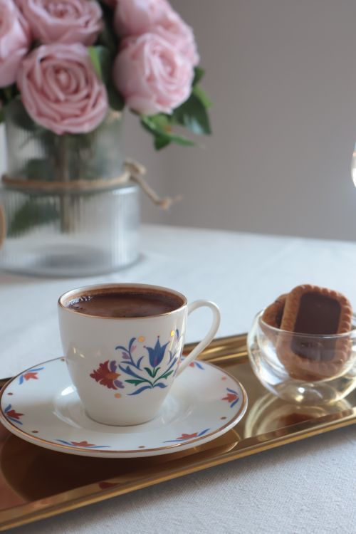 Free A beautifully arranged coffee setup with floral design and cookies, perfect for a cozy moment. Stock Photo
