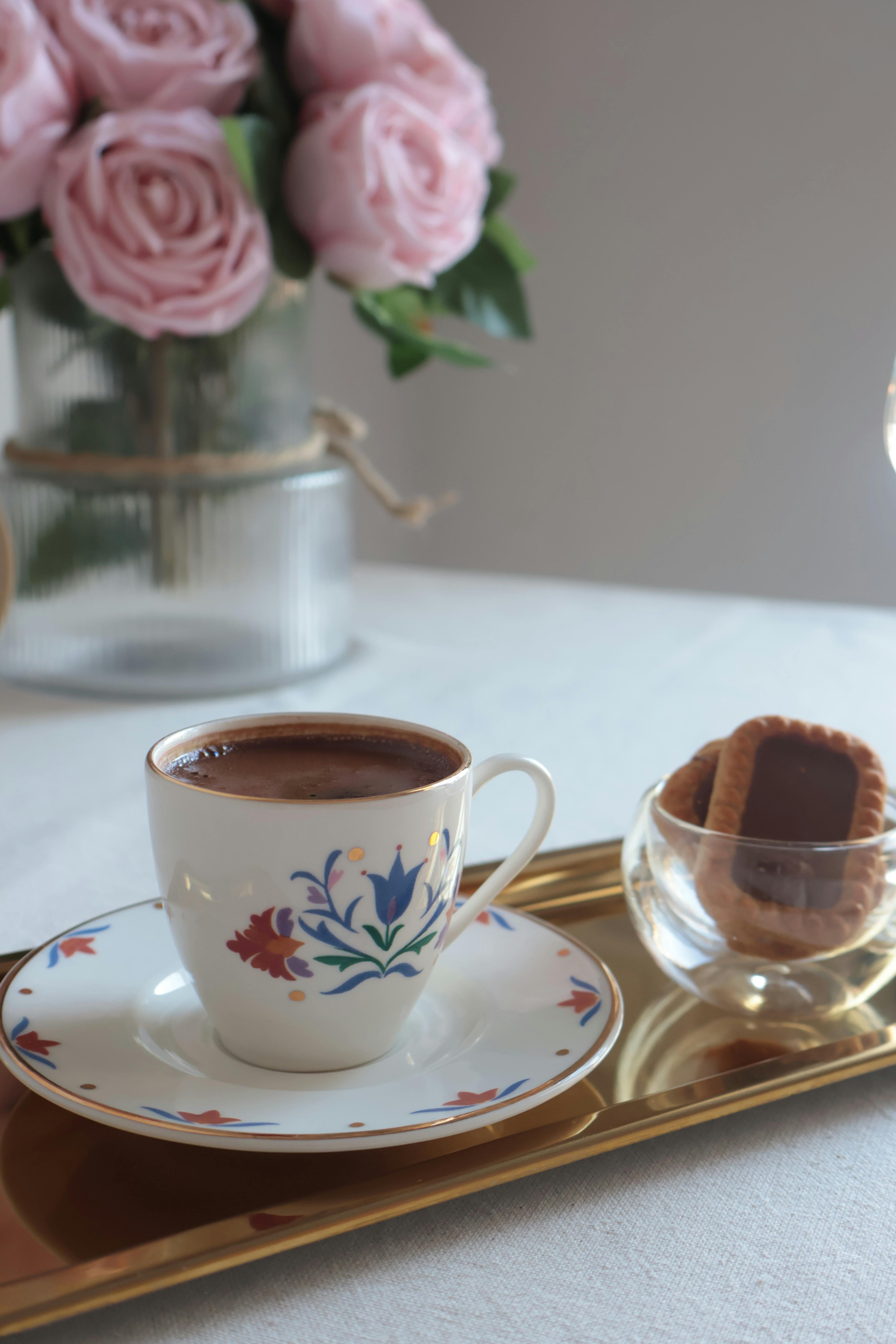 grátis Uma mesa de café lindamente decorada com arranjos florais e biscoitos, perfeita para um momento aconchegante. Foto profissional