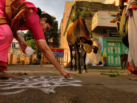 A woman designs a rangoli on a vibrant Indian street, capturing cultural essence.