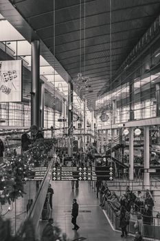 A bustling view of Kastrup Airport, Denmark, highlighting modern architecture and travelers in a monochrome setting.