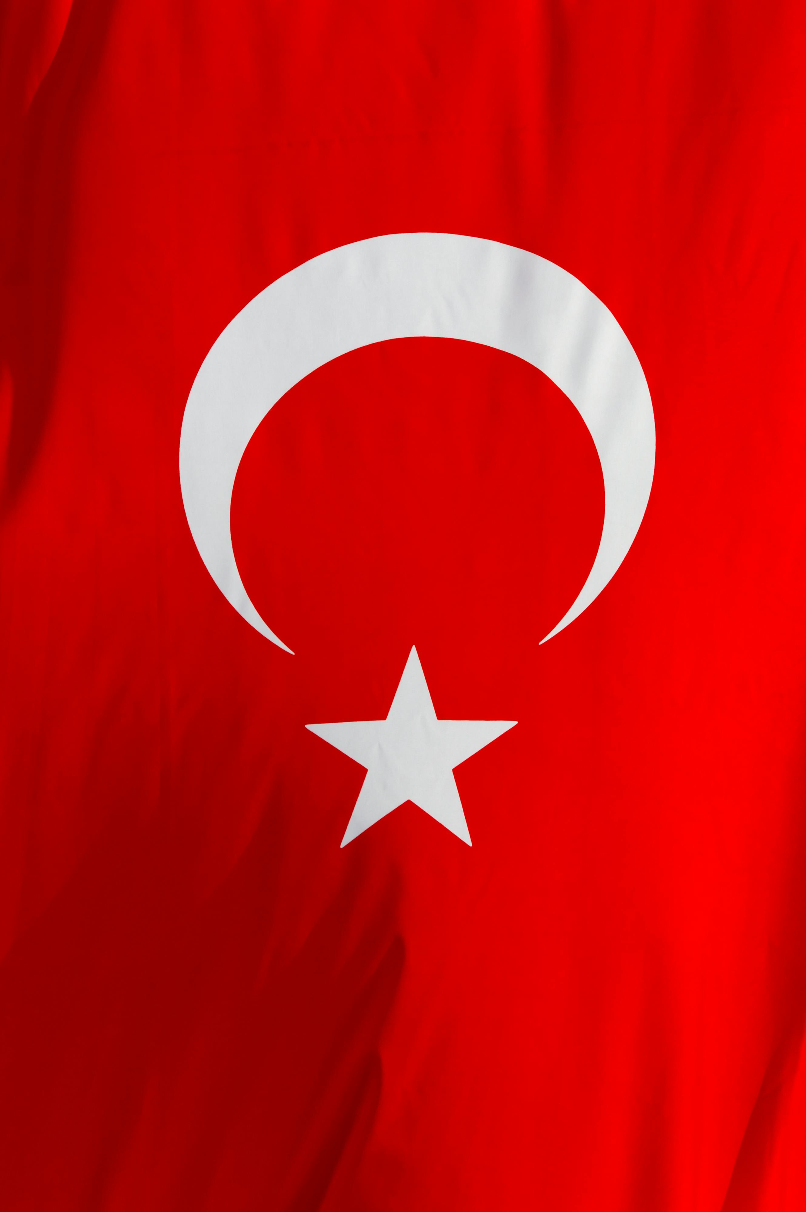 Close-up of the Turkish flag waving, showcasing the crescent and star symbol on a red background.
