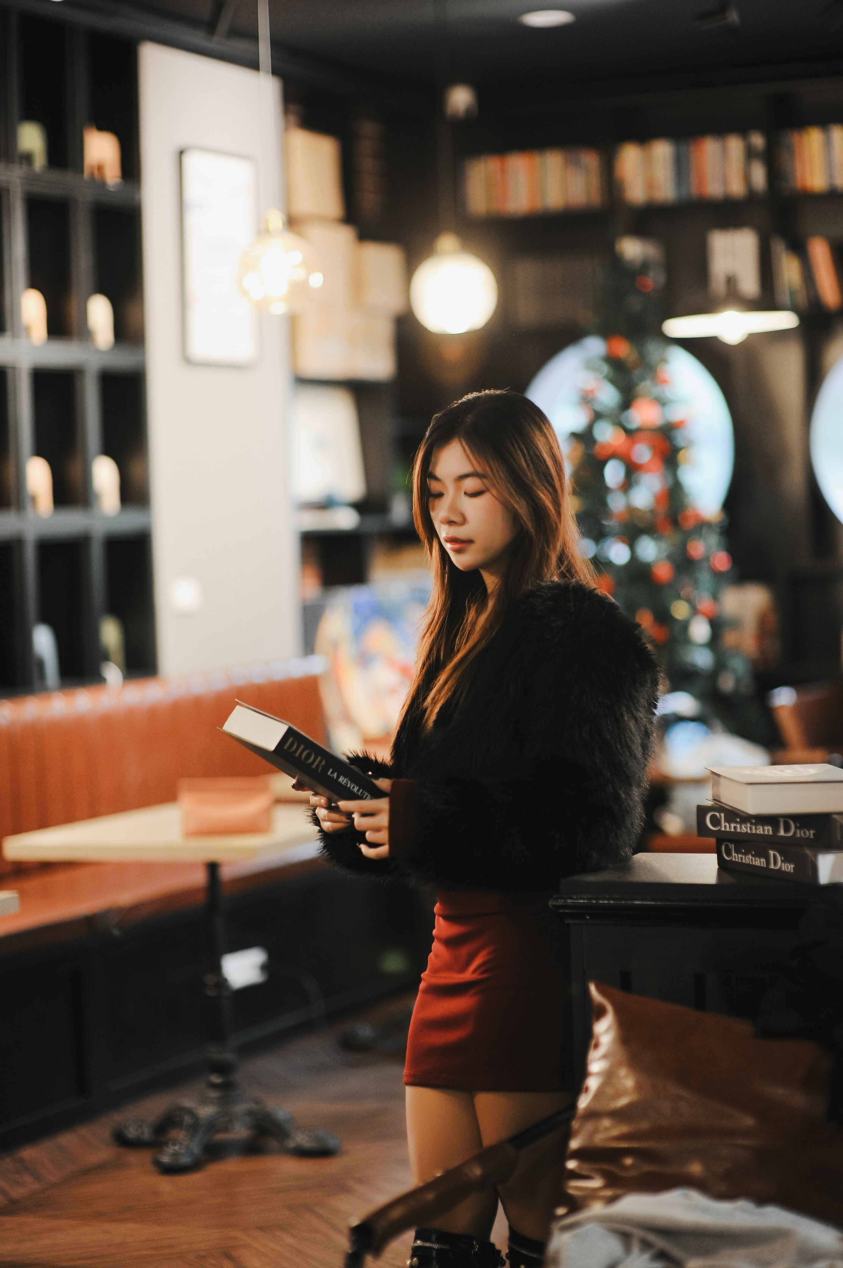 Young Woman Reading in Cozy Holiday Bookstore · Free Stock Photo