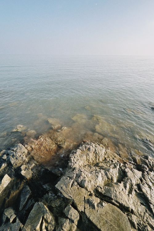 Free Peaceful view of the rocky shoreline by the calm waters in Konaev, Almaty Region, Kazakhstan. Stock Photo