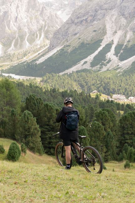 Mountain biker enjoys scenic view of Trentino-South Tyrol's rugged landscape.
