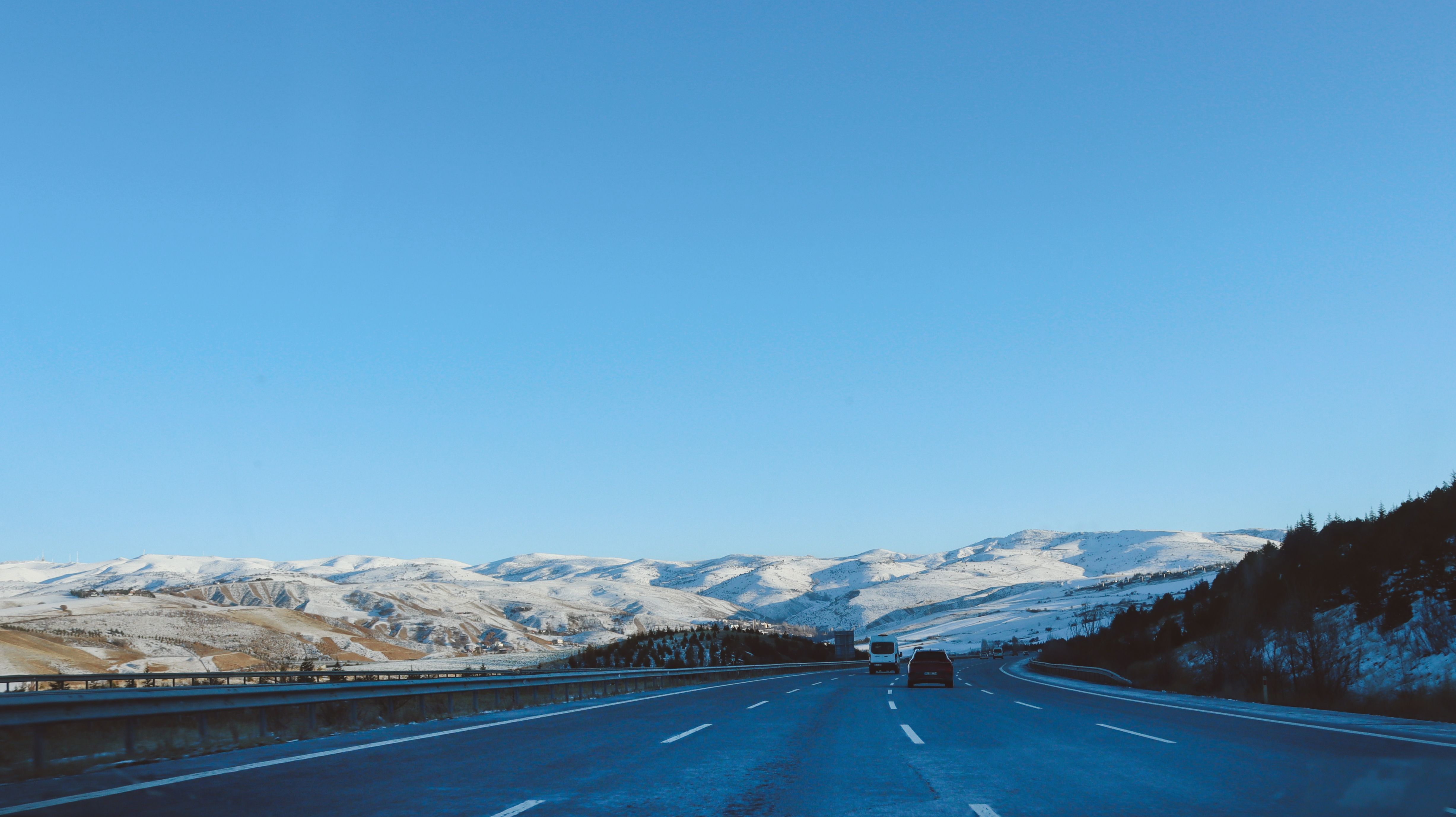 Snowy Mountain Highway Under Clear Blue Sky · Free Stock Photo