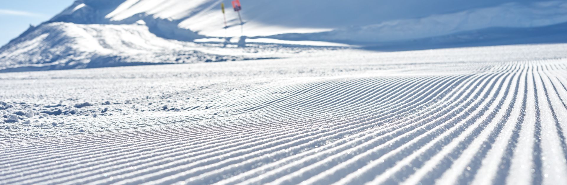 Pristine groomed ski slope under a bright winter sun in Schladming, Austria.