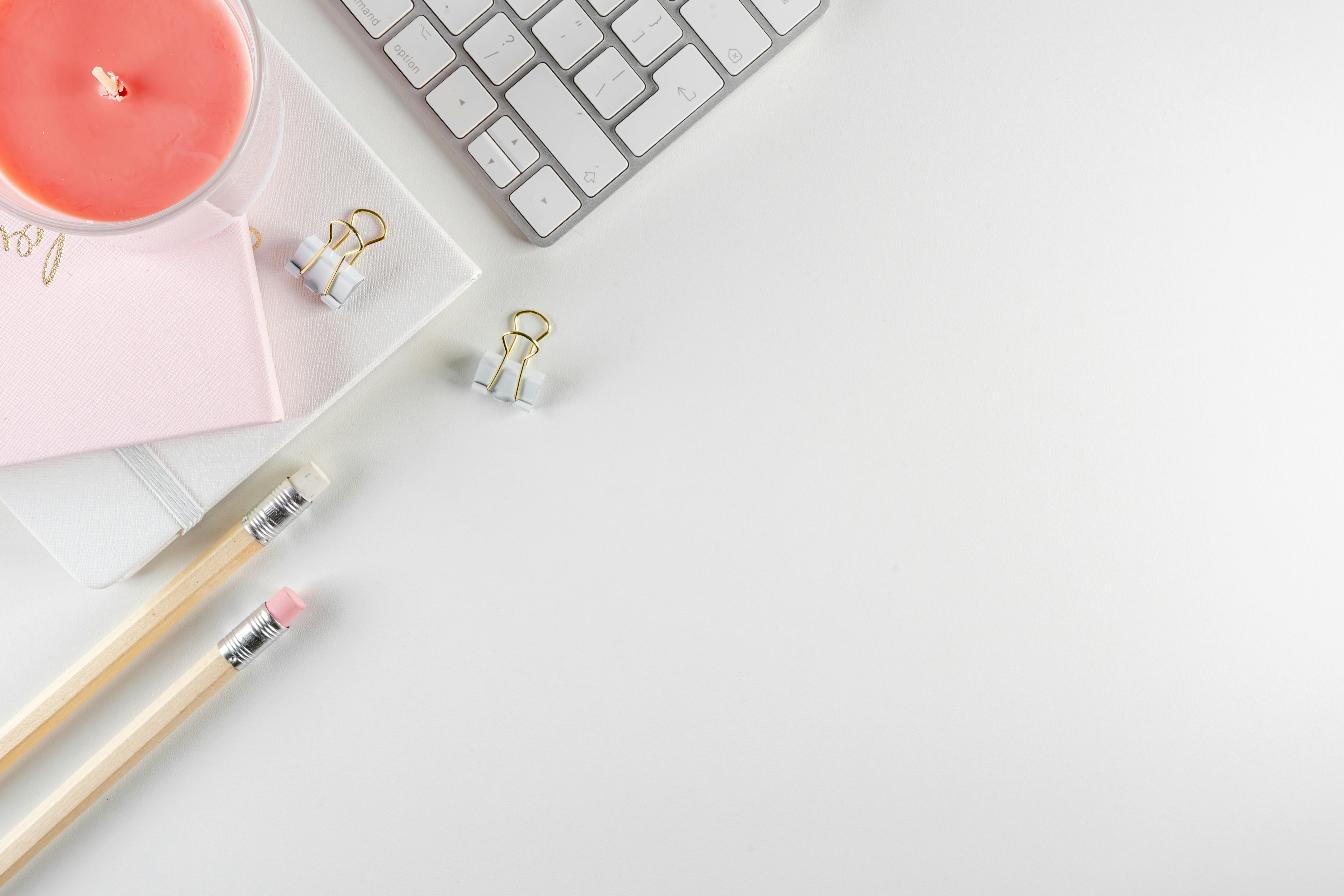 Kostenlos Stilvolles Flatlay eines Schreibtisch-Setups mit rosa Kerze, Tastatur und Schreibwaren für einen modernen Arbeitsplatz. Stock-Foto