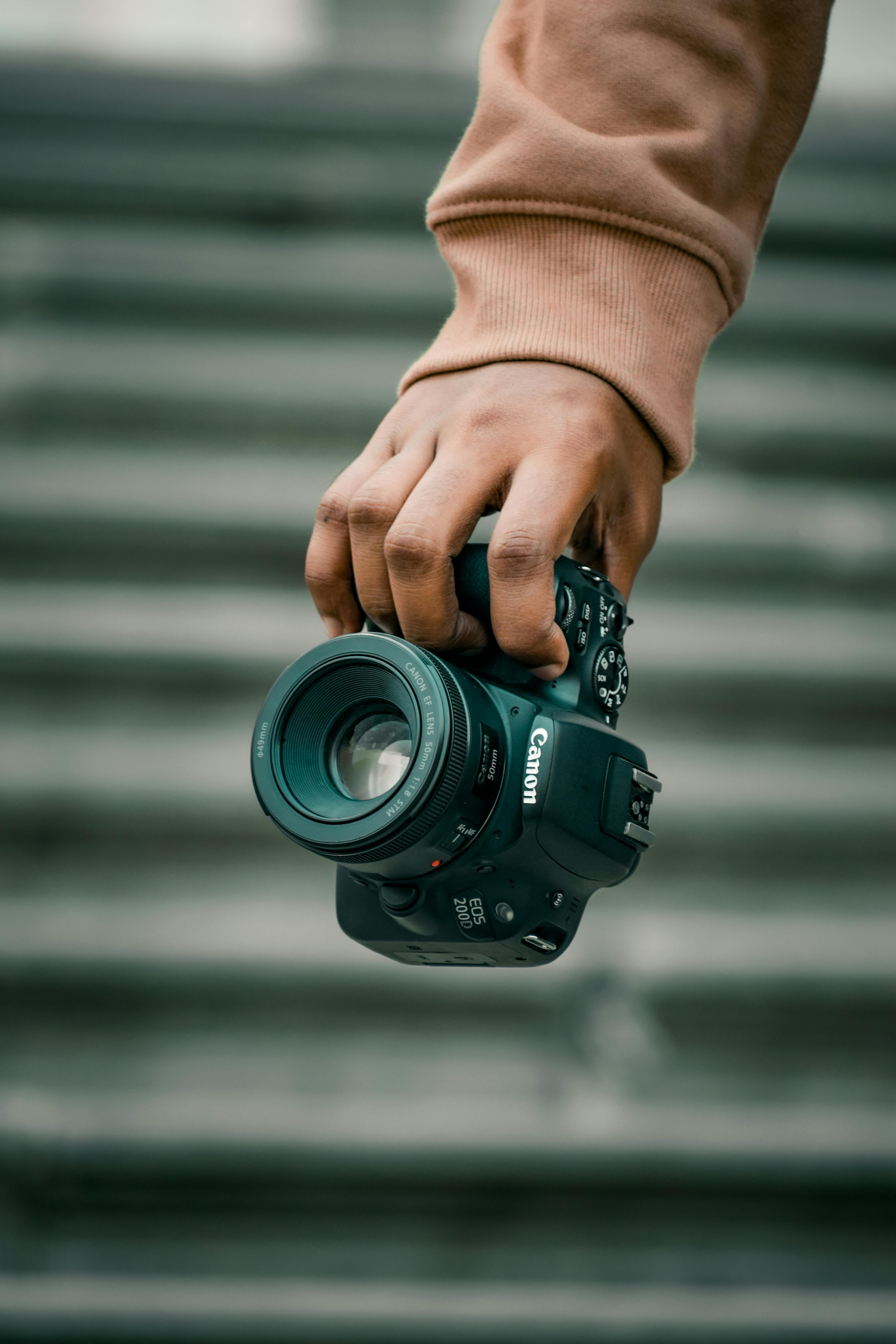 Person Holding Black Canon Camera · Free Stock Photo