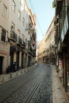 Tranquil view of a narrow cobblestone street lined with colorful buildings in Lisbon.