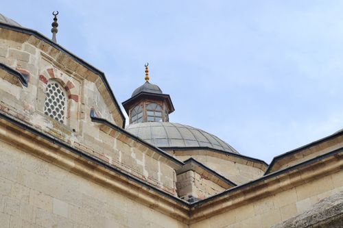 Free Close-up view of a historic mosque's dome and minaret against a blue sky. Stock Photo