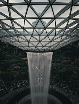Captivating view of Jewel Changi Airport's indoor waterfall with lush greenery and architectural marvels.