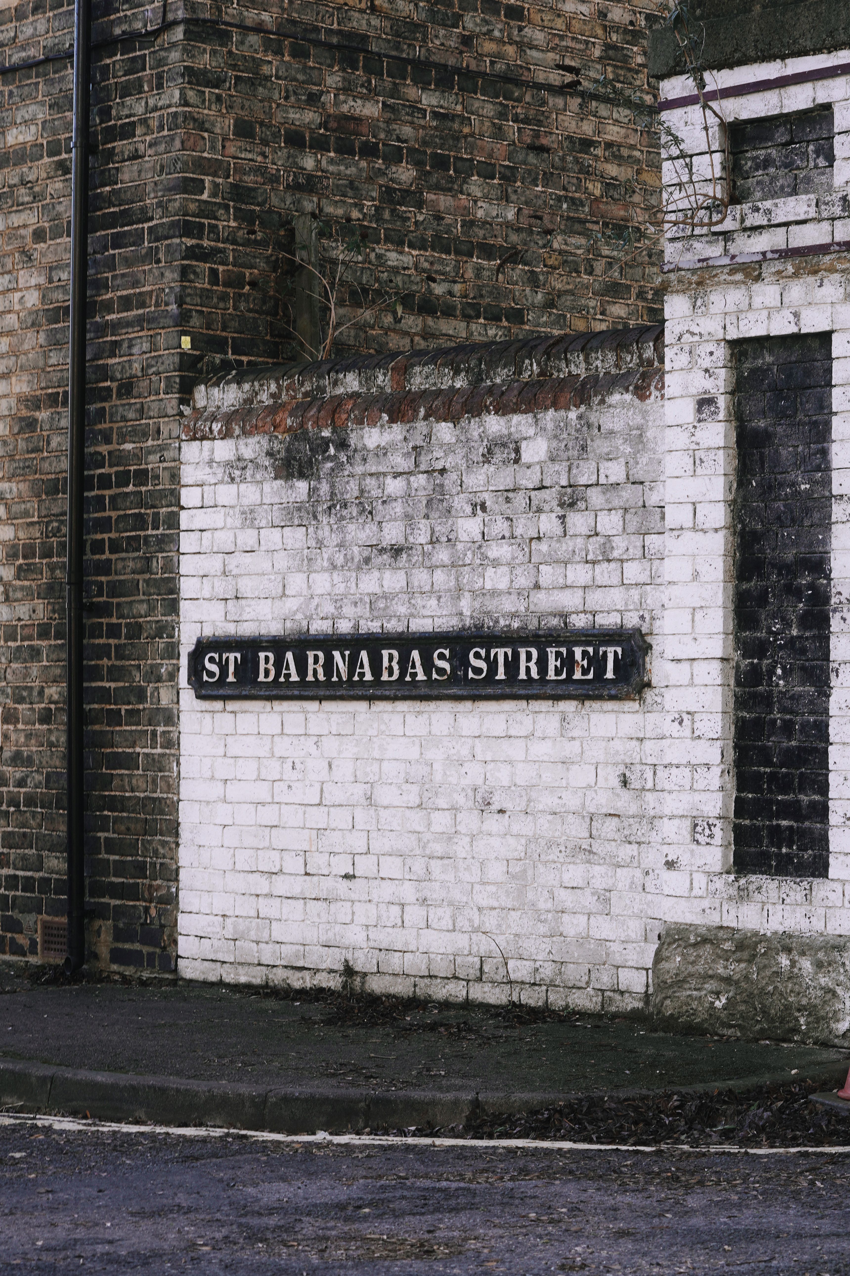 Vintage street sign on brick wall in England's St Barnabas Street.