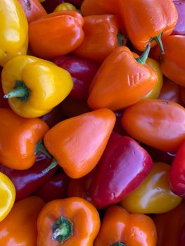 A vibrant display of fresh orange, red, and yellow bell peppers, providing a colorful and healthy food option.
