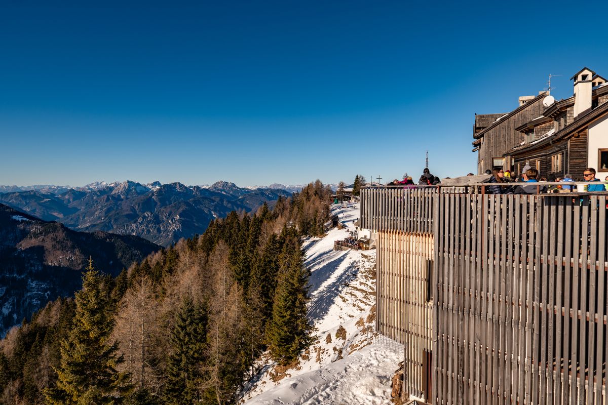 A mountain-restaurant terrace above a vast blue valley