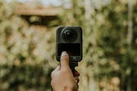 Close-up of a Hand Holding a 360 Camera Outdoors