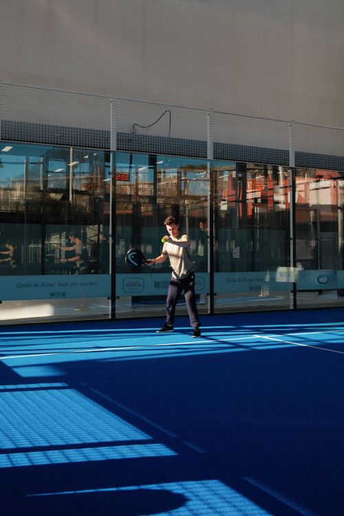 Free Adult playing paddle tennis on a striking blue court in Lisbon, Portugal. Stock Photo