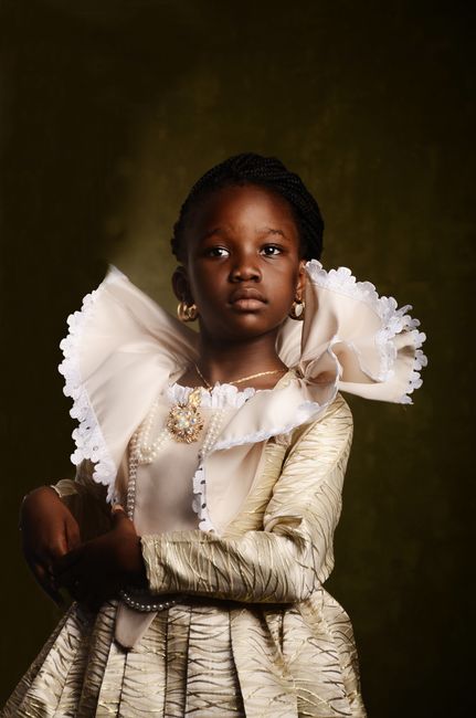 A striking portrait of a young girl wearing a luxurious traditional dress with intricate detailing.