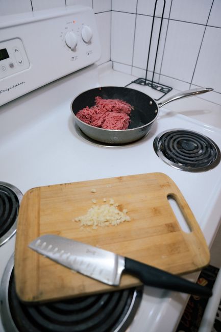 Raw ground beef in a butcher tray showing a mix of bright red surface color and grayish-brown color underneath where it wasn't exposed to air.