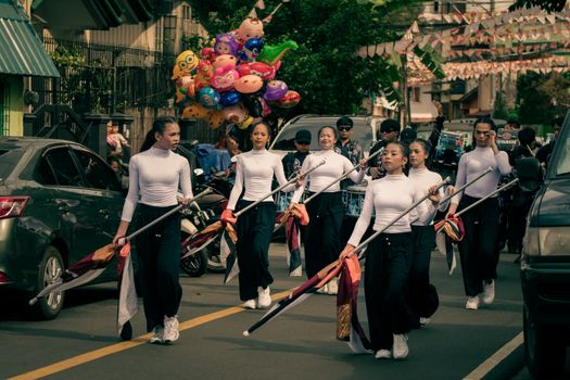 A colorful street parade featuring a color guard team marching with vibrant flags and balloons. - Fotografer Sidoarjo