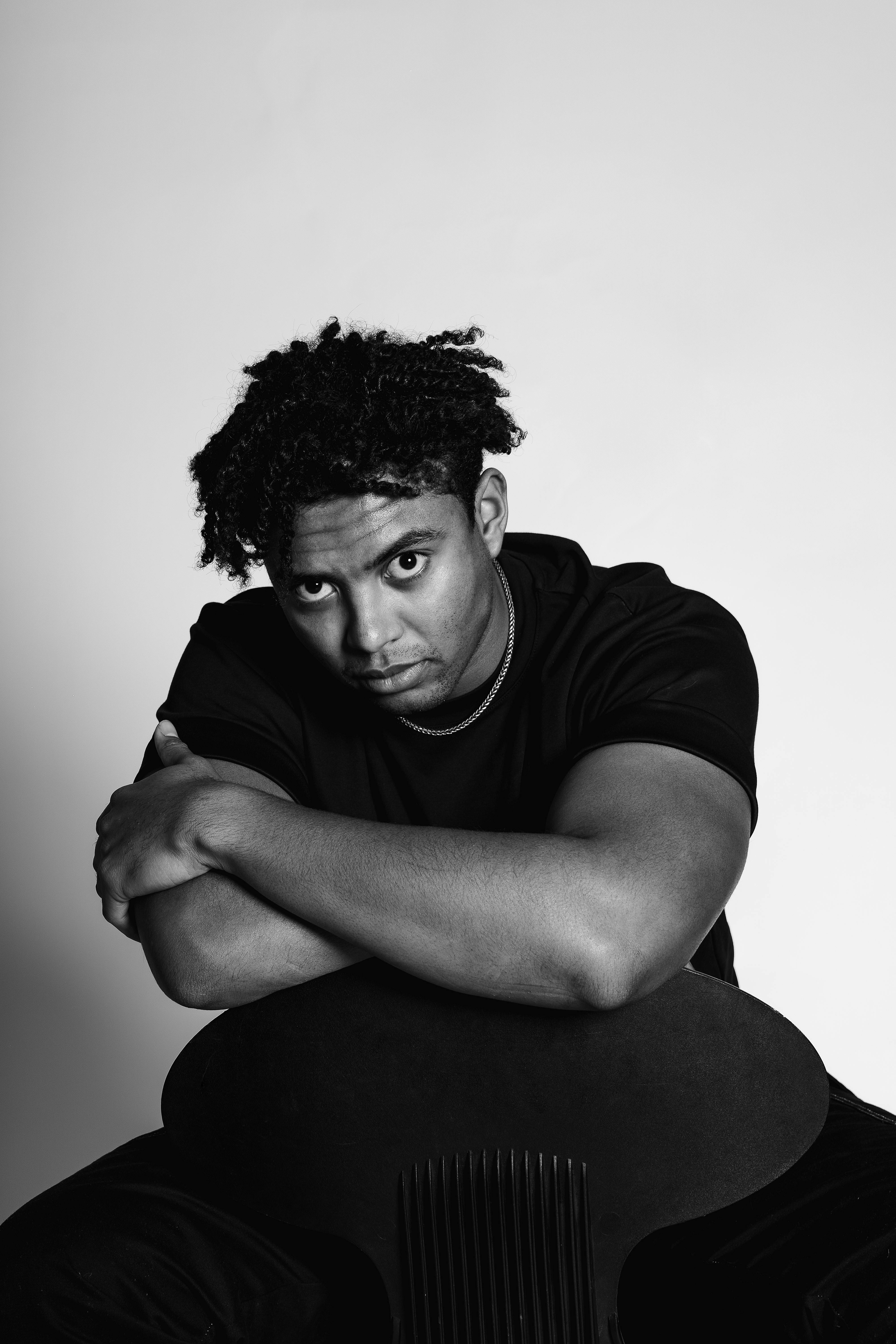 grátis Retrato marcante em preto e branco de um jovem contemplativo sentado. Foto profissional