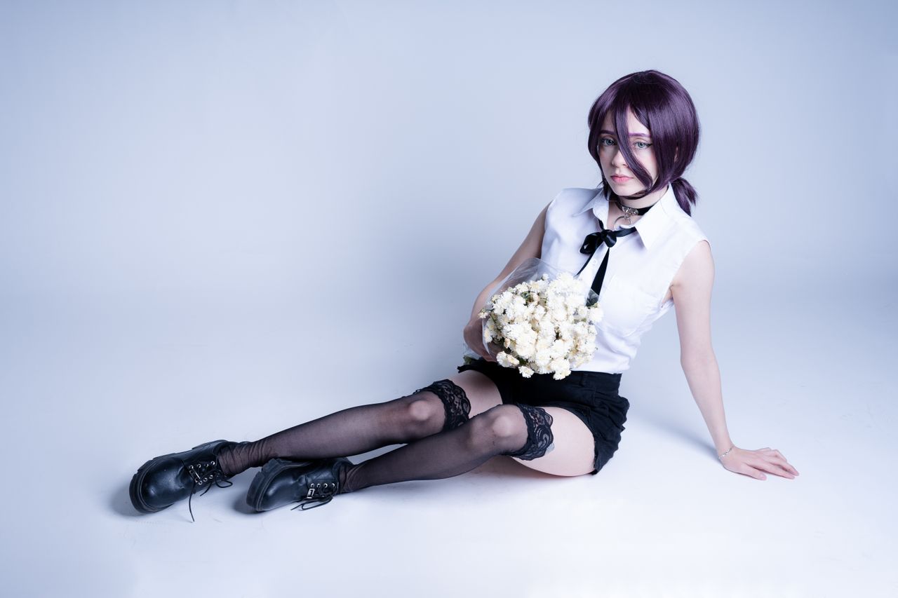 young woman in anime cosplay holding white roses against a minimalist