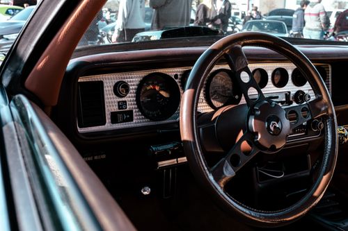 Free Interior view of a vintage car showcasing the classic steering wheel and dashboard design. Stock Photo
