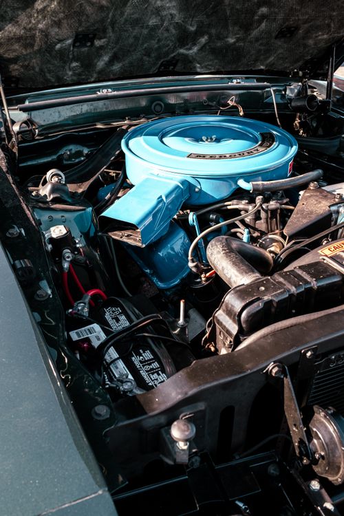 Free Close-up of a vintage car engine featuring a bright blue air filter, showcasing automotive details. Stock Photo