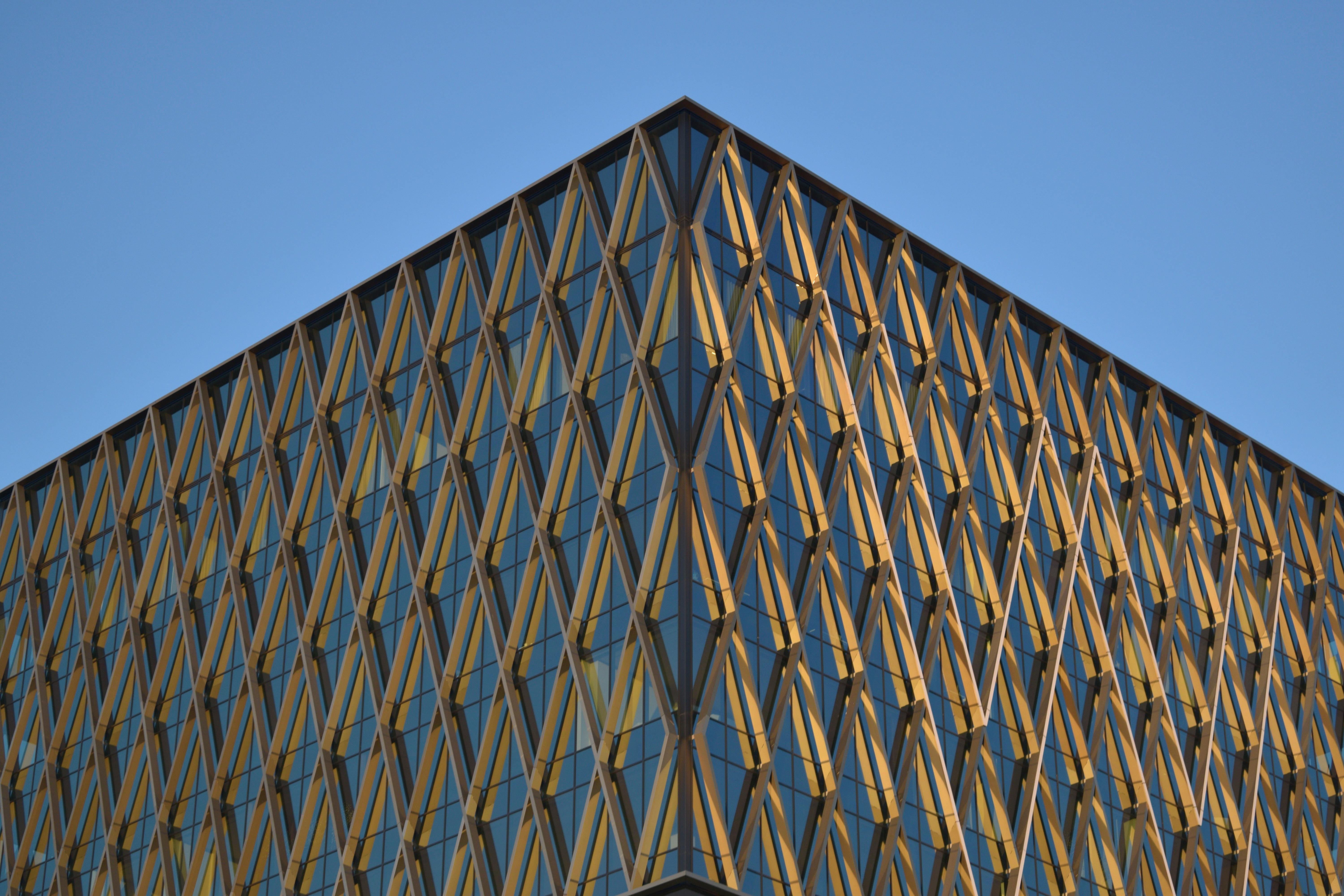 Kostnadsfria En modern byggnad med en unik geometrisk fasad mot en klarblå himmel. Stock foto