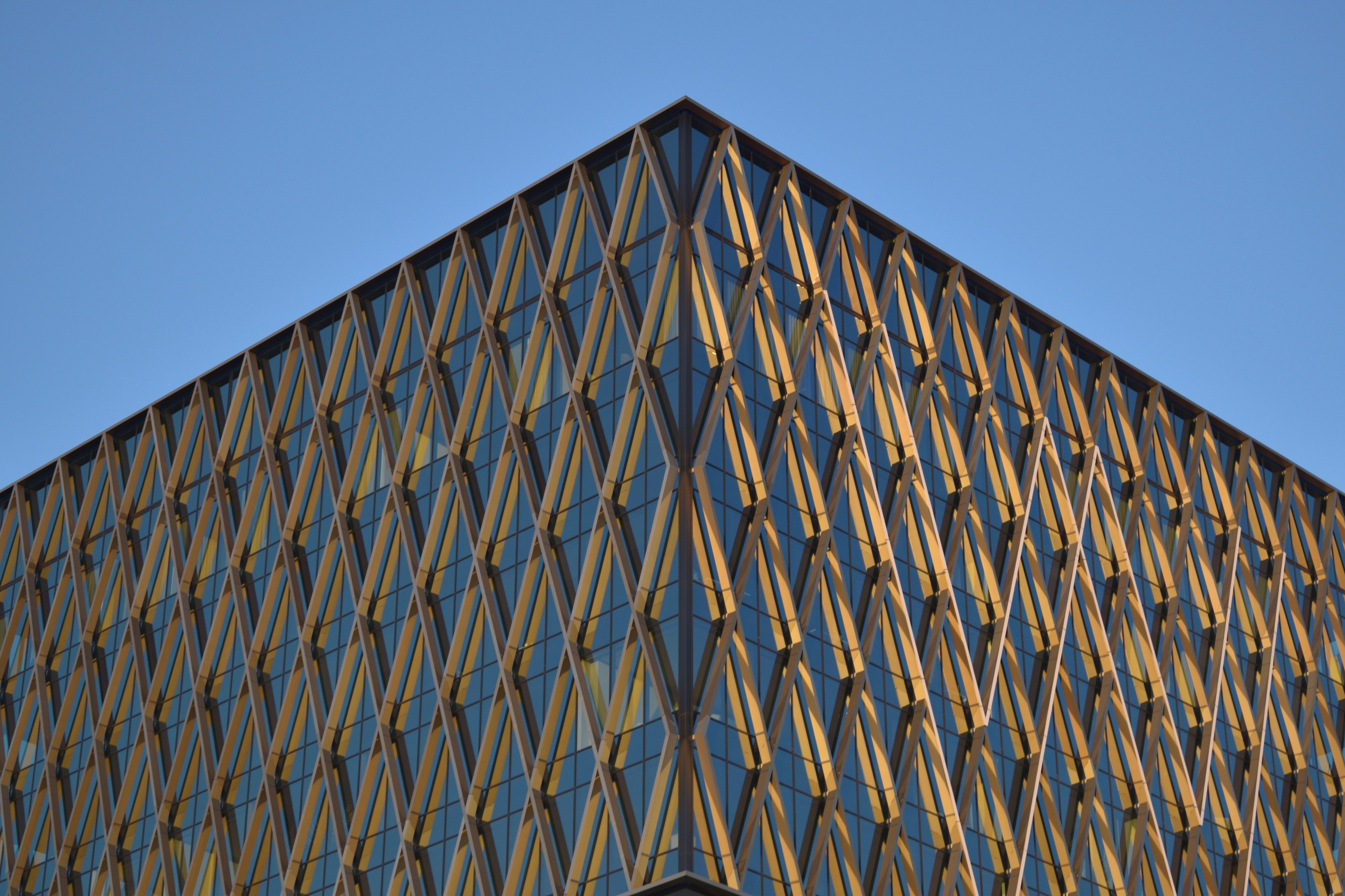 Gratis En moderne bygning med en unik geometrisk fasade mot en klar blå himmel. Arkivbilde