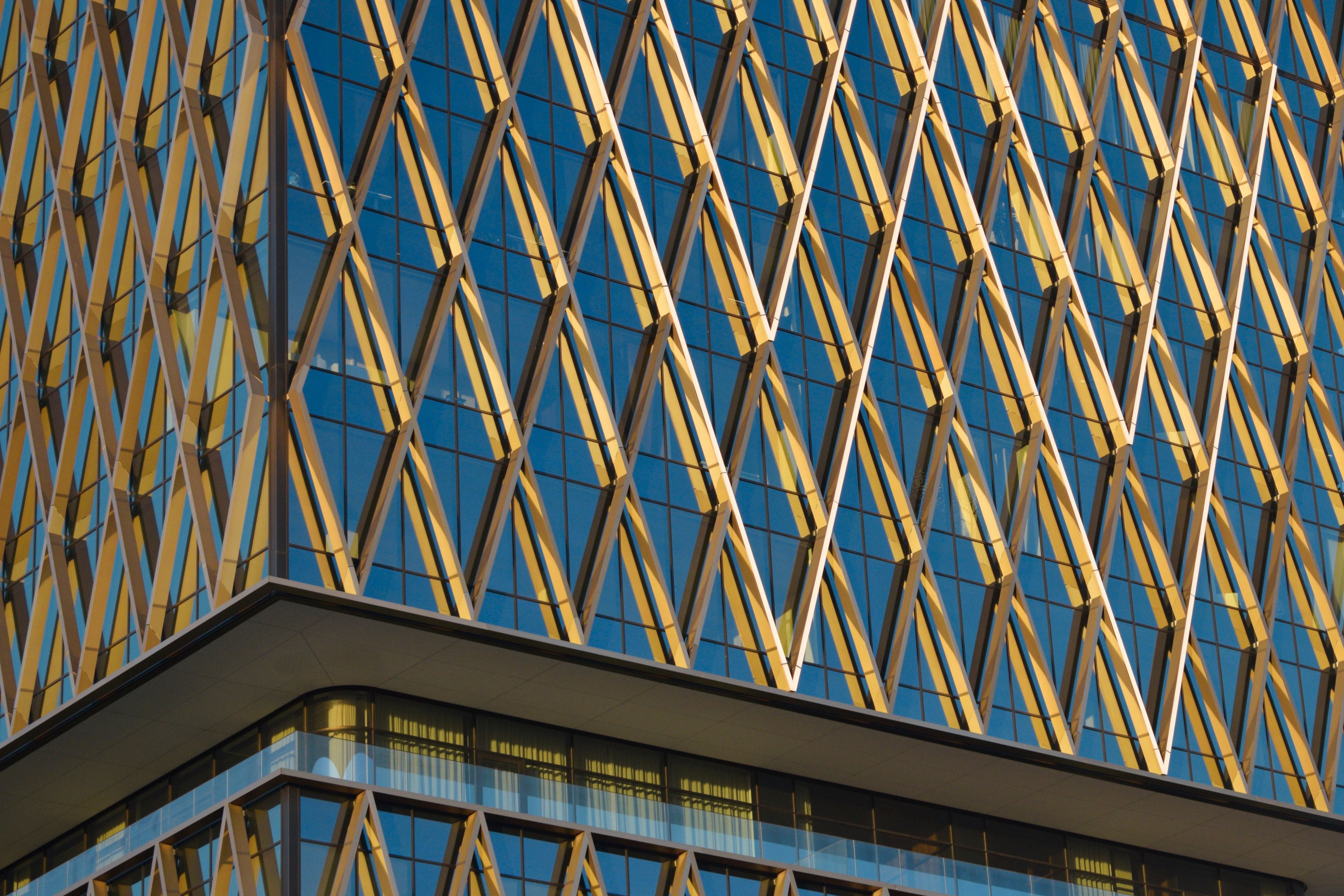 Modern Glass Building with Geometric Facade · Free Stock Photo