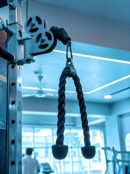Close-up of gym equipment with rope pulley, fitness background in modern gym.