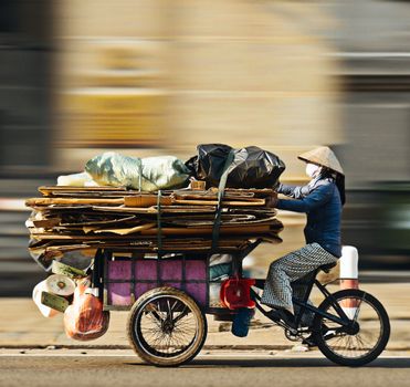 Bicyclist collecting recyclables in Ho Chi Minh City, embodying sustainable living and urban recycling.