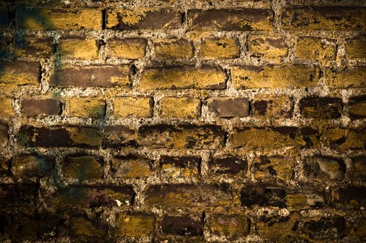 Close-up of an old, textured brick wall with vignette in warm tones.