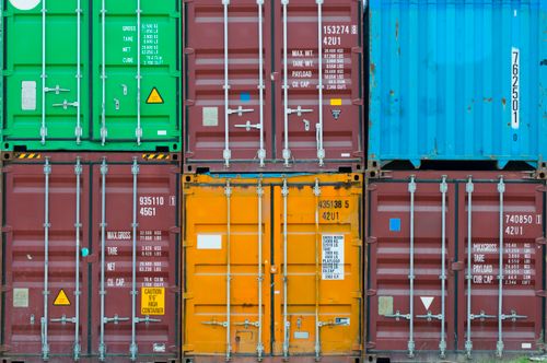 Free Vividly colored shipping containers stacked together, showcasing global trade and logistics. Stock Photo